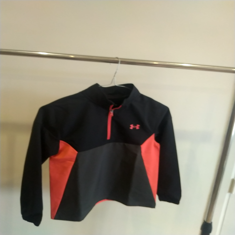 Image de Under Armour - Vêtement de Golf Coupe Vent Juniors Noir/Orange disponible sur ekwip